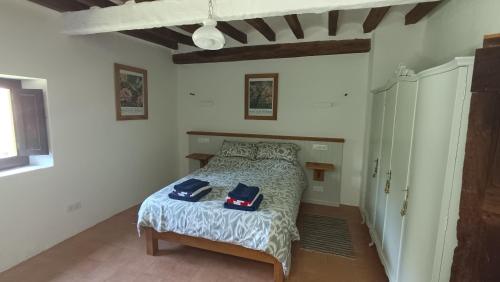 a bedroom with a bed with two bags on it at Spacious Country House for 8 near Olot Remote Work & Nature Escape in Olot