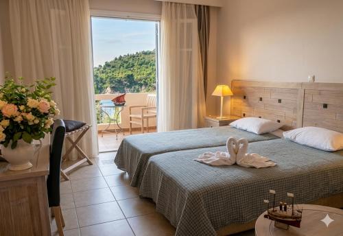 a hotel room with a bed and a large window at Alonissos Beach Bungalows And Suites Hotel in Alonnisos