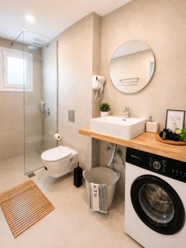a bathroom with a washing machine and a sink at Pagonia Apartments in Arillas