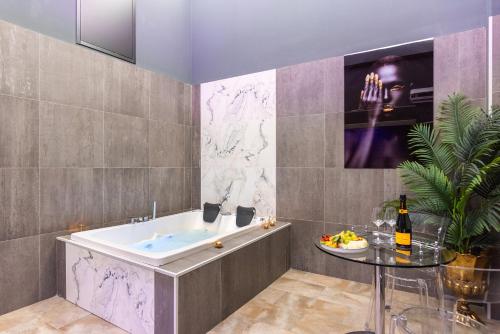 a bathroom with a tub and a glass table at Kore Luxury Suite e Spa in Naples