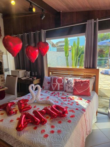 a bed with valentines hearts hanging above it at Luz Residence suíte in Cabo Frio