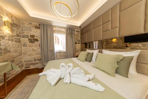a bedroom with a bed with a white bow on it at Hotel Corsaro in Omiš
