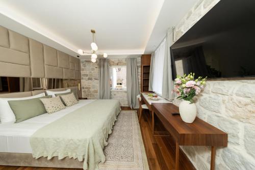 a bedroom with a bed and a table with flowers on it at Hotel Corsaro in Omiš