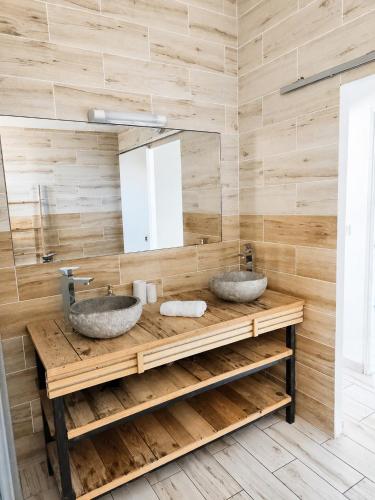 two sinks on a wooden counter in a bathroom at Villa des trois singes in Saint-Pierre