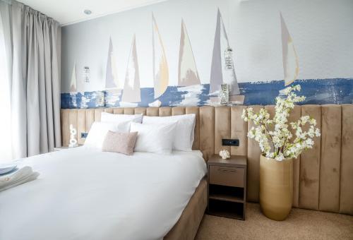 a bedroom with a bed and a vase of flowers at Boutique Hotel Solterra - Crikvenica in Crikvenica