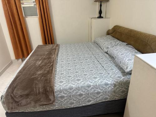 a bedroom with a bed with a blanket on it at Glynver Apartments in Christ Church