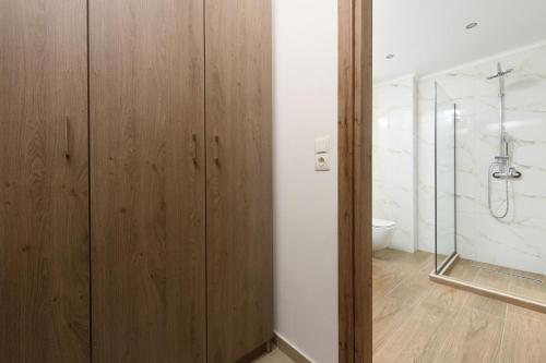 a bathroom with wooden cabinets and a shower at VILLA TOSTi & VILLA JOY in Skala Rachoniou