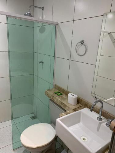 a bathroom with a shower and a toilet and a sink at Suítes nativa in Trairi