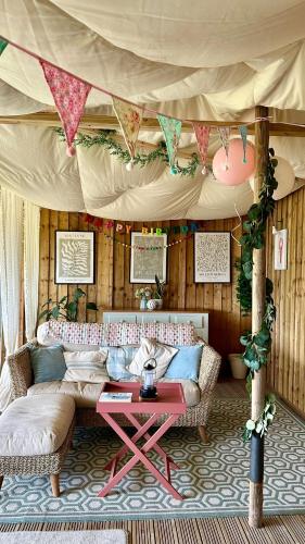 a living room with a couch and a table at Tregantle Farm Eco GLAMPSITE in Torpoint