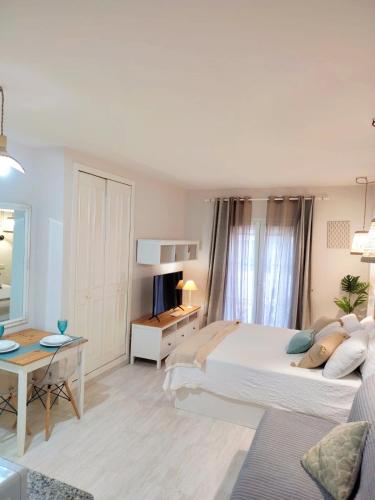 a bedroom with a large bed and a living room at LolaSuite Confort in El Rocío