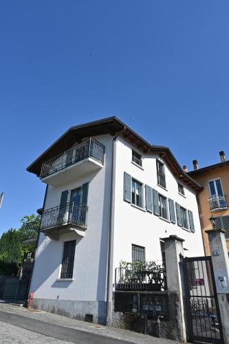 a white building with balconies on a street at Appartamento Bonita Vista in Colico