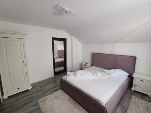 a bedroom with a large bed and a mirror at Casa Drăgan in Novaci-Străini