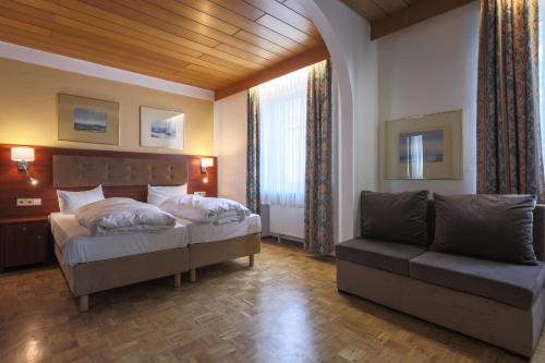 a bedroom with a bed and a couch at Hotel Starkenburger Hof in Heppenheim an der Bergstrasse