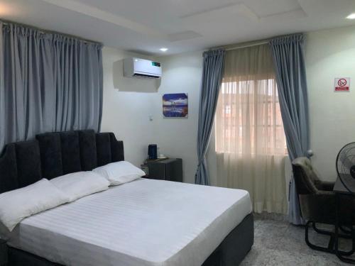a bedroom with a large bed and a window at Pointax Apartment Lekki in Ilado