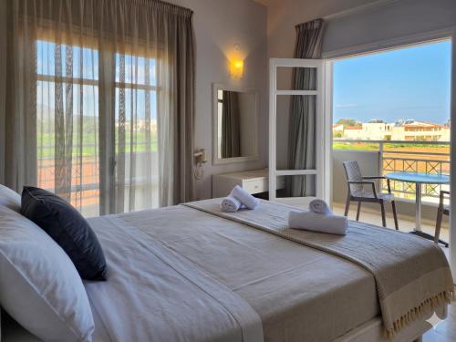 a bedroom with a large white bed with a balcony at Matthew's Place in Malia