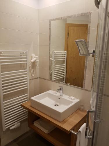 a bathroom with a sink, toilet and bathtub at Hotel Dolomiten in Dobbiaco