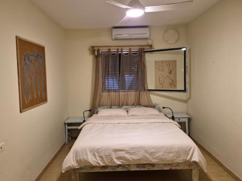 a bedroom with a large bed in a room at מתחת לעץ התות בכפר in Bet Alfa