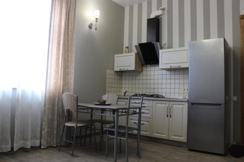 a small kitchen with a table and a refrigerator at Strong Five apartment in Sumy