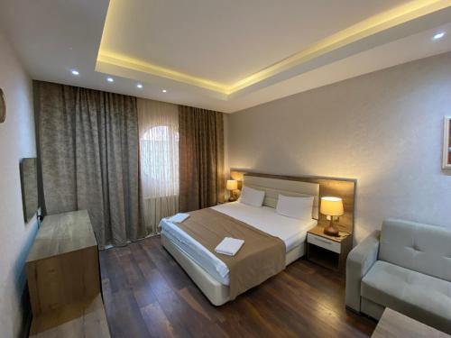 a bedroom with a bed and a couch and a chair at Absheron Marina in Baku