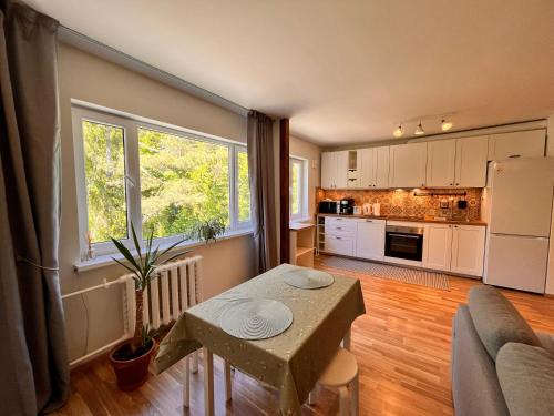 a living room with a table and a kitchen at Leisi Forest View Apartment in Leisi