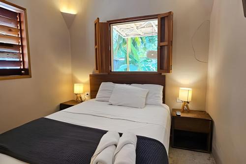 a bedroom with a large bed with a window at CASA 2 HAB Alberca y Parking privado in Bacalar