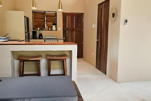 a kitchen with a counter and a table with stools at CASA 2 HAB Alberca y Parking privado in Bacalar