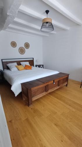 a bedroom with a large bed with a wooden table at Pont Menou Bretagne in Plouégat-Guérand