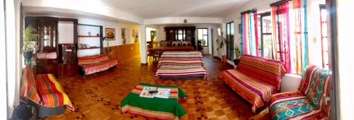 a room with chairs and a table and windows at Spanish Friends in Sucre