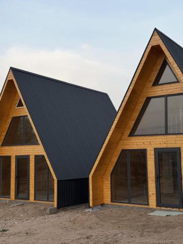 a large wooden house with a black roof at Tosor Medet A-frame in Tossor