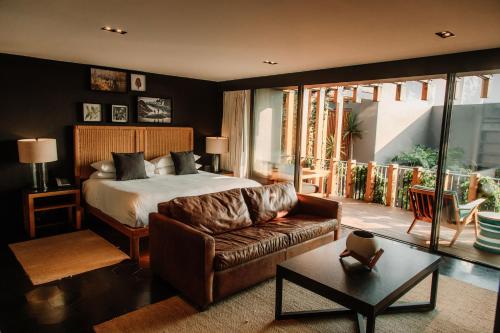 a bedroom with a bed and a couch in a room at Cinco Rodavento in Valle de Bravo