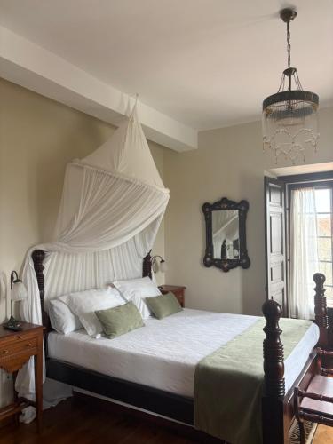 a bedroom with a white bed with a canopy at Hotel Palacio La Casona de Cerrazo in Cerrazo