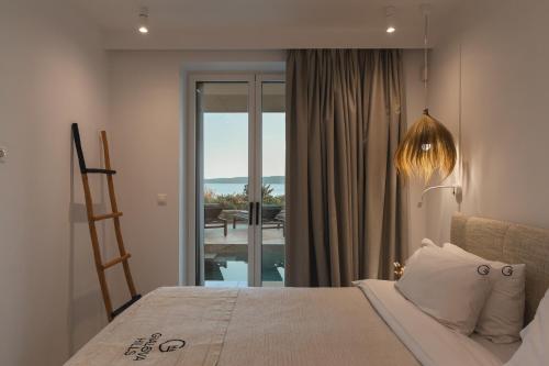 a bedroom with a bed with a view of a balcony at Villa Ammos with Private Pool, Sauna & Seaview in Gialova