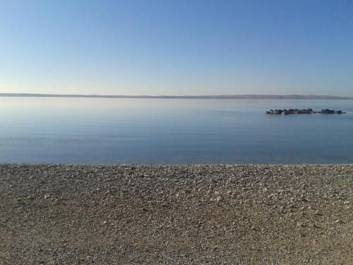 a large body of water with a rocky shoreline at Mobile Homes Vila Punta in Šibuljina