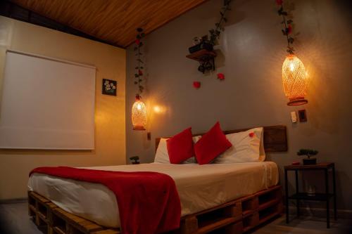 a bedroom with a bed with red and white pillows at Glamping Entre Rocas Tena in Tena