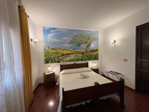 a bedroom with a bed and a painting on the wall at Le Zarafe in Caltabellotta