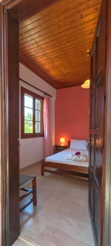 a bedroom with a bed and a wooden ceiling at Revival rooms in Nikiana