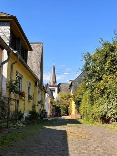 a cobblestone street in a village with a church at Ferienwohnung Alte Metzgerei in Mesenich