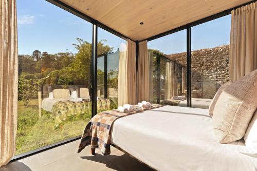 a bedroom with a bed and large glass windows at Sûr Jumigny in Jumigny