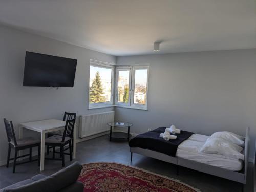 a bedroom with a bed and a table and chairs at Apartamenty Słoneczna 42 in Gdynia