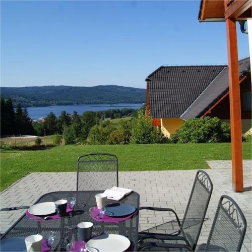a table and chairs on a patio with a view at LIPNO Hideaway in Kramolín