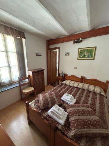 a bedroom with a bed with two towels on it at Albergo Passet in Pragelato