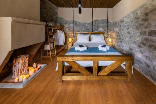 a bedroom with a bed in a room with a stone wall at PETRASTERO Mountain Retreat-Agrafa Evrytania Greece in Vérnikon