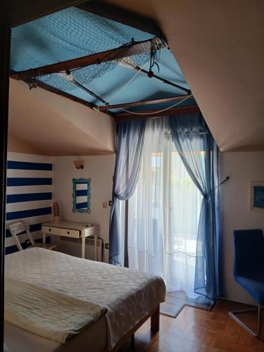 a bedroom with a bed and a window at Villa Verde Apartments and Rooms in Premantura