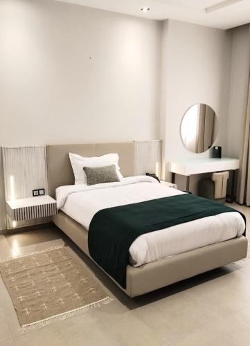 a bedroom with a large bed and a mirror at Hotel Maamoun in Gafsa