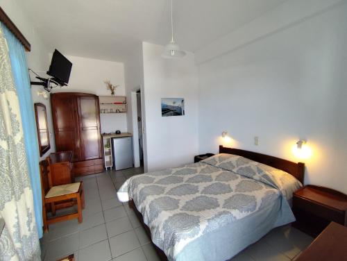 a bedroom with a bed and a television in it at Areti studios in Vathi