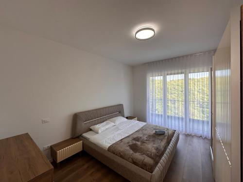 a bedroom with a bed and a large window at Villa Luxury Forest in Peje