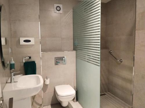 a bathroom with a toilet and a sink and a shower at Hotel Maamoun in Gafsa