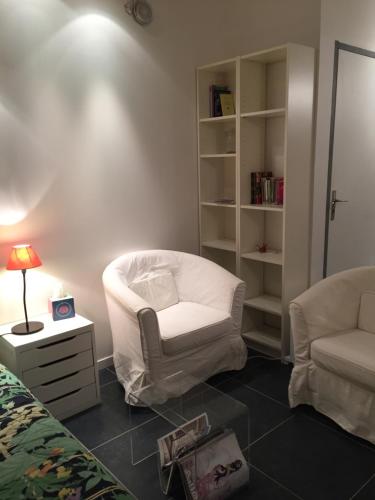 un salon avec une chaise blanche et une lampe dans l'établissement Charmant Studio Brignoles, à Brignoles