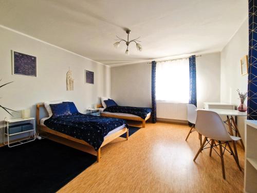 a living room with two beds and a table at Rozbrykany Muflon in Witoszów Dolny