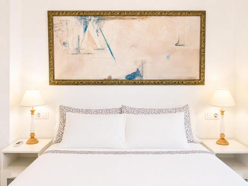 a bedroom with a white bed and a painting on the wall at Seaside Apartment Retreat in Benicàssim